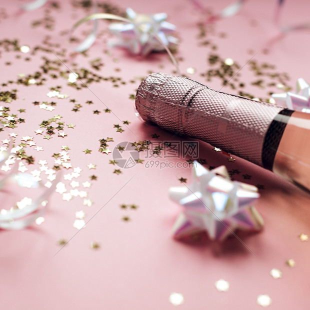 明信片圣诞或新年配有玫瑰香槟和金光闪的星彩蛋白在粉色面背景上边观党庆祝会创意概念的歌唱会庆典流光图片