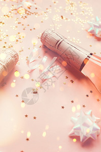 火花葡萄酒圣诞或新年配有玫瑰香槟和金光闪的星彩蛋白在粉色面背景上边观党庆祝会创意概念的歌唱会聚图片