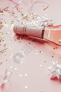 粉色的女化圣诞或新年配有玫瑰香槟和金光闪的星彩蛋白在粉色面背景上边观党庆祝会创意概念的歌唱会喝背景图片