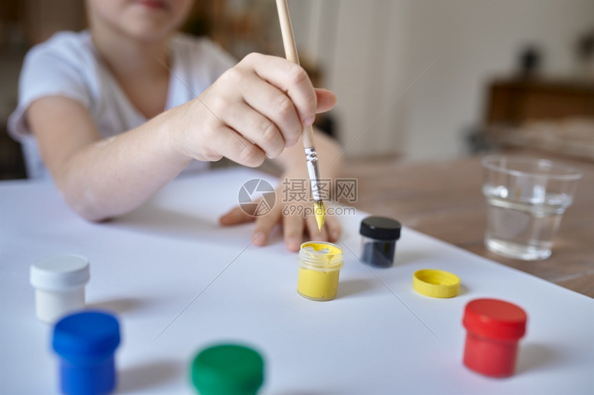 工作室水粉颜色小男孩在桌边用古阿切画小男孩在艺术学校上讲课的孩子年轻画家愉快的爱好童年小男孩用古阿丘画小男孩工作间里的子图片