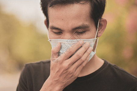 亚洲男子使用外科面具或罩保护2019年的冠状或公开消费19采用流感图片