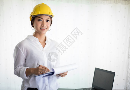 亚洲妇女工程检查作和持有蓝图的亚洲妇女在办公室中工作及持有蓝图笔记本电脑内部的管理图片