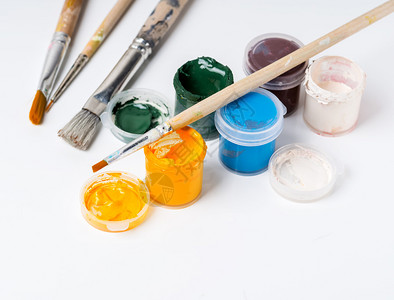 丰富多彩的画学校为儿童提供的有创意开瓶罐配有油漆和刷白色背景的漆和彩色谷瓜涂料图片
