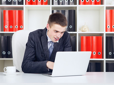 有自信的青年商人在办公室看笔记本电脑的年轻商人经理的业图片