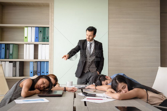 商人看着员工睡在办公室会议的员工们每天晚上10点5分生气的笔记本电脑图片