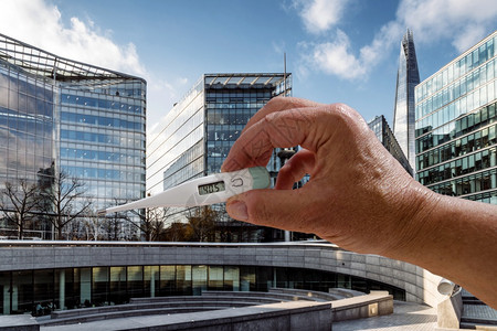 伦敦市背景的高温手持式度计冠状Covid19概念摩天大楼展示云图片