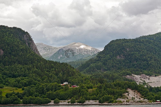 自然在多云的天空下挪威安道尔尼斯附近的Romsdalsfjorden沿线山区的小房子挪威安道尔尼斯附近的沿线风景优美斯堪的纳维亚图片