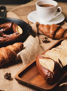 法国面包羊角和加咖啡杯的麻布面条早餐概念椒盐卷饼白色的新鲜图片