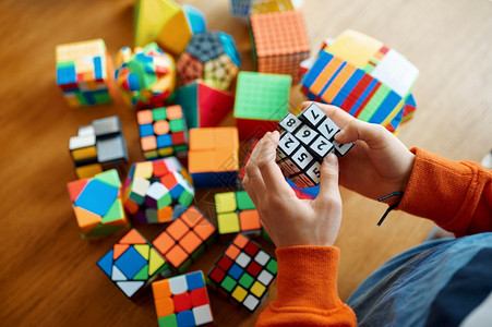 合乎逻辑的解决方案小男孩拿着数字的拼图立方体玩具用于大脑和逻辑心智训练创意游戏解决复杂问题小男孩拿着数字的拼图立方体有创造力的图片