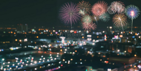 在模糊的摩天大楼上放多彩烟花在夜晚抽象新年节日或派对背景点亮城市布OK灯光中心城景观假期图片