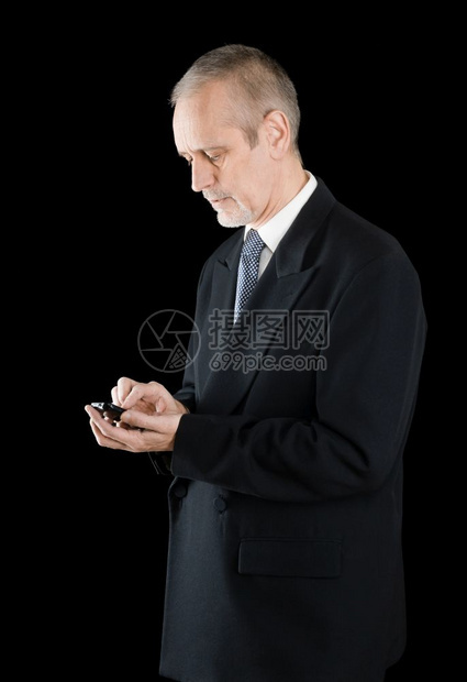 黑西装高级商人在手机上用黑色背景写短号或拨以黑人背景打字愉快英俊的图片