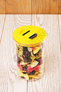 食物塑料容器中不同颜色的原弓面条意大利彩色不同木制的里加蒂图片