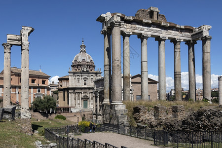 游客纪念碑历史土星神庙和左侧的维斯帕芗神庙和提图斯在意大利罗马市的广场上几个世纪以来逐渐倒塌只剩下前门廊矗立在卡比托利欧山脚下的图片