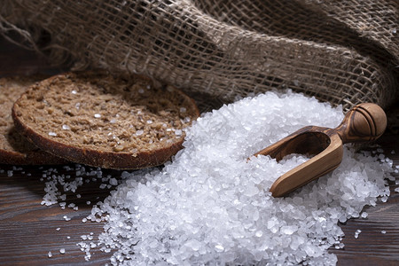 味道矿物用于在烧木桌上烹饪食物的白海盐天然勺面包和粗袋用于在深色木桌上烹饪食物的白海盐面包和粗袋最佳图片