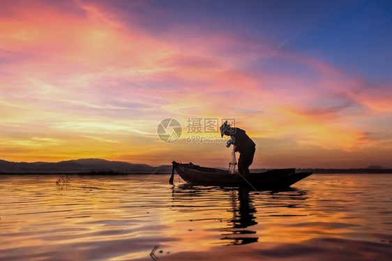 日落缅甸工作在自然湖中日出时在自然湖中的木船上渔民轮椅图片