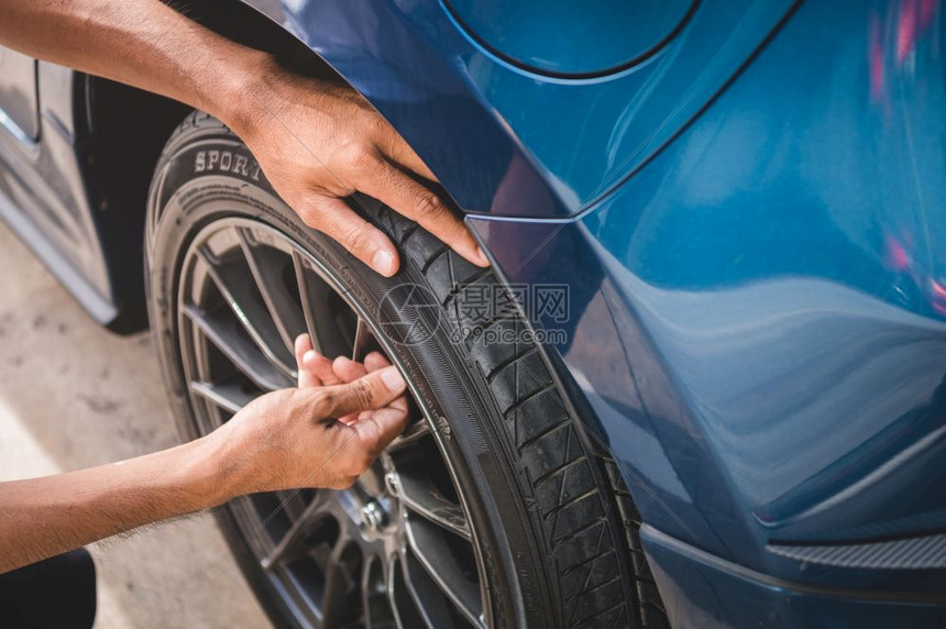在停车场或加油站因轮胎膨胀服务而取消轮胎阀门氮气上限的汽车技师年度保养和维修概念安全公路旅行和主题车辆年度保养和修理查看车库轮图片