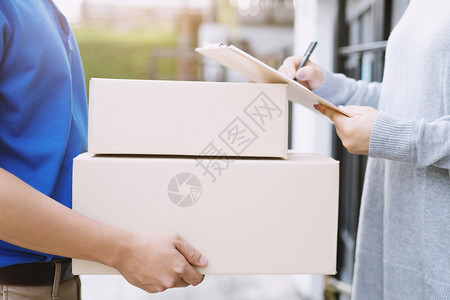 家门抠年轻的包裹男人送信员用手拿着的箱子敲家门铃响了背景