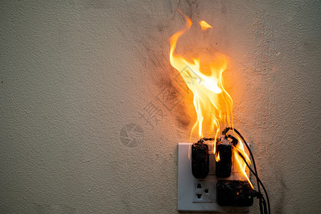 电短路故障导致电线被烧在白色背景的电受控器上造成电线被烧火抽烟气图片