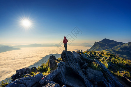 在泰国清莱站立岩石上的旅行者Doiphatang和晨雾云摄影师黎明图片