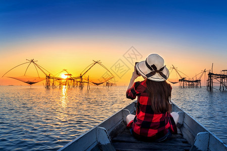 女旅行者在泰国Phatthalung的Pakpra给渔网拍照天空美丽的日落图片