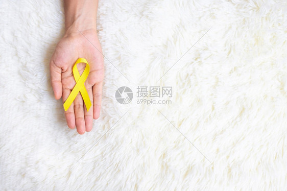 手拿黄色丝带预防概念图片