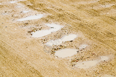 贫穷公路上的脏水坑农村地区基础设施封闭泥坑道路关农村供水管道脚印领域潮湿图片