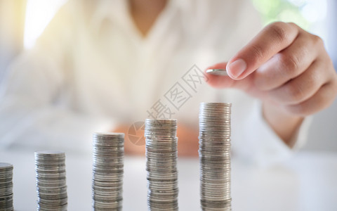会计速度妇女经商堆钱硬币投资和银行业务概念堆叠图片