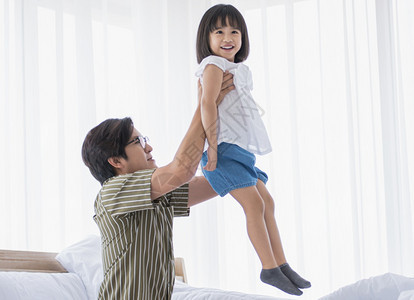 他的亚洲爸在节假日度过快乐时光在家和女儿一起玩耍休息开支图片