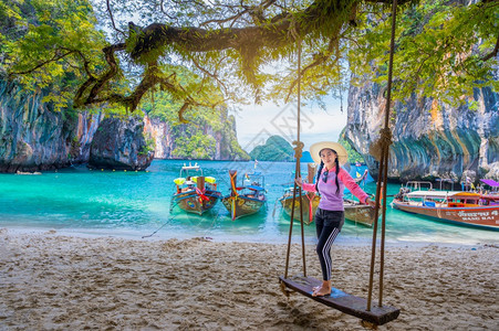 蓝色的戴帽子坐在泰国高老挝克赖比岛上的妇女和海景旅游图片