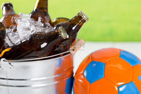海滩蓝色的足球和啤酒在冷水桶里鬼图片