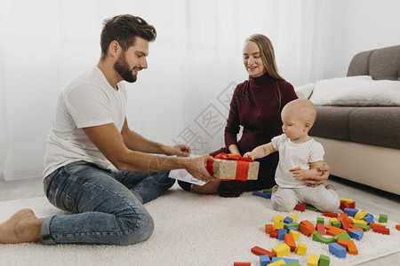 情侣礼物快乐父母给孩子送礼物的家庭婴儿沙发背景