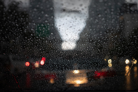街道挡风玻璃当汽车在深夜路中间时车尾灯照亮了汽镜子上雨滴反射的车尾灯光而ThimpicRain则变得模糊不清抽象的图片