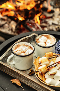 喝两杯咖啡可或热巧克力和烤棉花糖的切片在营火期间使用秋季节假日户外招待食物或者图片