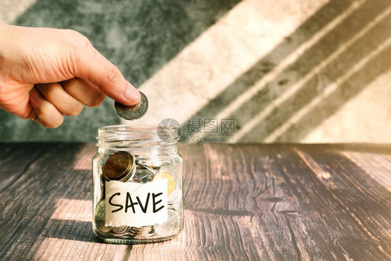 利润省钱女人把硬币放在玻璃罐里为了节省金钱的融概念商业会计图片