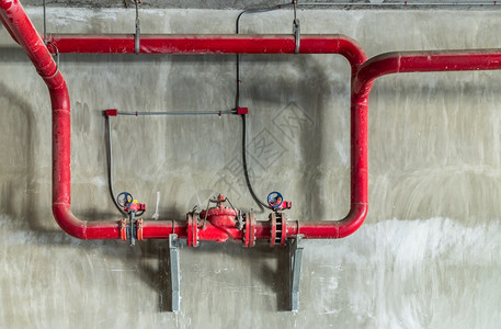 工业管和阀门线道工业和灭火器泵制版空间选择焦点在水泥墙上装有大门压力阀的红水或天然气管道控制红色的可选择图片