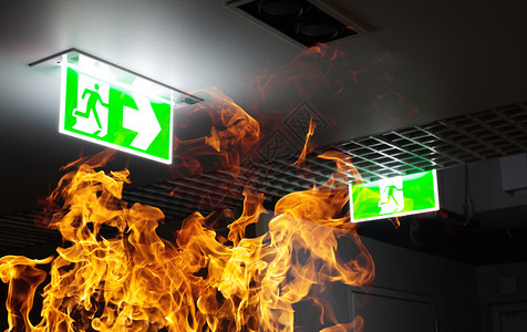 抽烟地面夜间办公室的天花板上挂着热火和绿色逃生标志防训练和疏散准备的概念方向图片