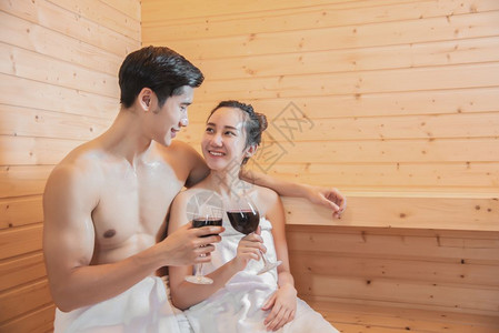 汗亚洲情侣在桑浴室喝葡萄酒用蒸汽假日和放松概念处理热水富有的美丽图片