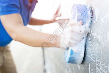 男人瓜拉纳皮手握蓝色海绵洗车涤图片
