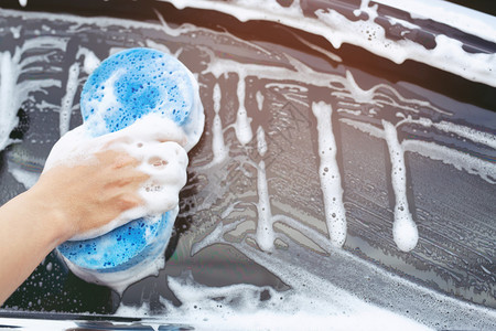 闪耀家人手握蓝色海绵洗车工作图片