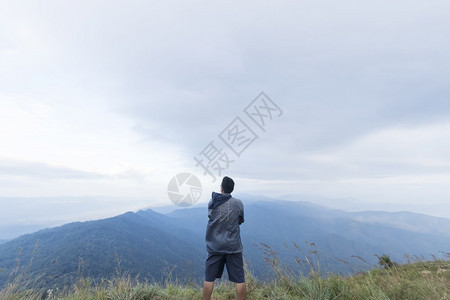 旅行攀登青年男子站在山顶上立图片
