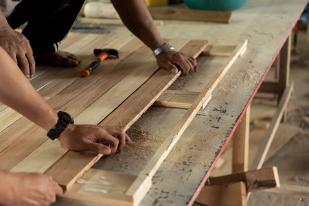 亚洲木匠在仓库或材工厂锯的仓库或用天然硬白板和制材造家具或产品用于建筑或销售木匠在材工厂建造家具供出售或者自然植物图片
