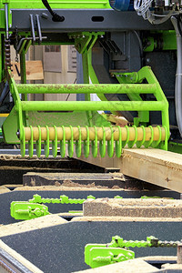 材料锯木厂磨工新鲜锯松板由现代自动锯木机用固体材垂直图像制成的现代化自动锯木机生产将梁锯成一个现代木机上的新板图片