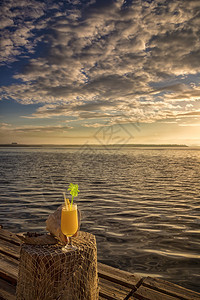 海日出洋在热带岛屿的日落鸡尾酒节时以木制餐桌为背景的鸡尾酒和稻草阳光桌子美丽图片