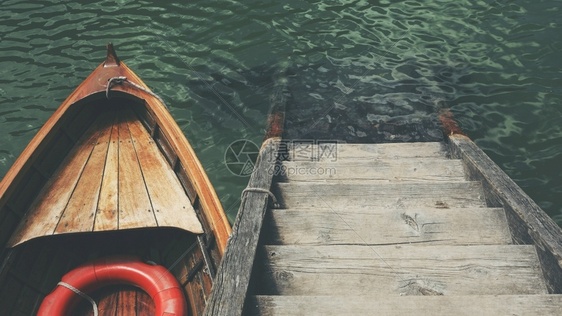 美丽海中木楼梯附近一艘小船的高角照片美丽海中木楼梯附近一艘小船的高角照片海浪老的孩子们图片