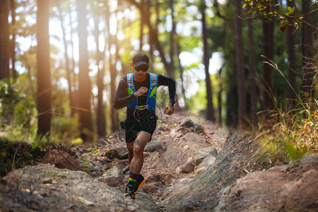 骑着运动鞋在森林中跑步的脚下穿着运动鞋在森林中奔跑路赛者为了图片