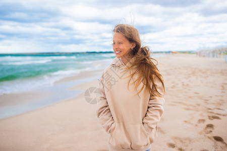 年轻的热带女孩在美丽的沙滩上行走图片