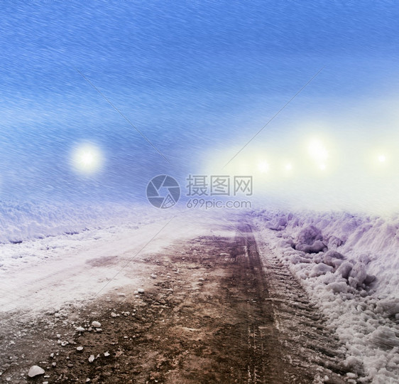汽车高速光滑的寒雪笼罩着冬天的街道夜里闪亮的街灯图片