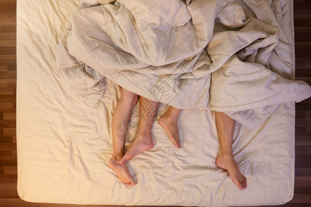 浪漫的脚丫子在卧室床单下的上男女双脚紧贴地亲近热情图片