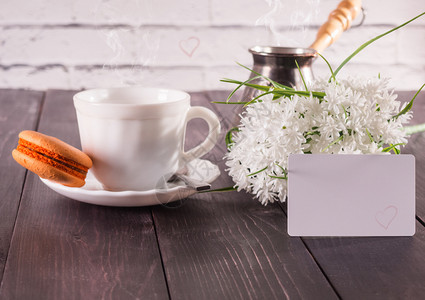 咖啡茶碟上加红花和束卡片的鲜花复制白色团体图片