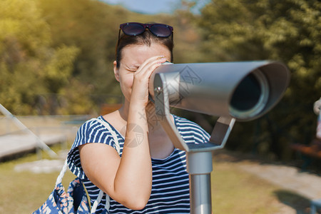 自然年轻的夏季穿暑服年轻女游客利用望远镜观看秋天在希腊斯塔基拉亚里士多特勒斯柯公园从山上看场景夏天图片